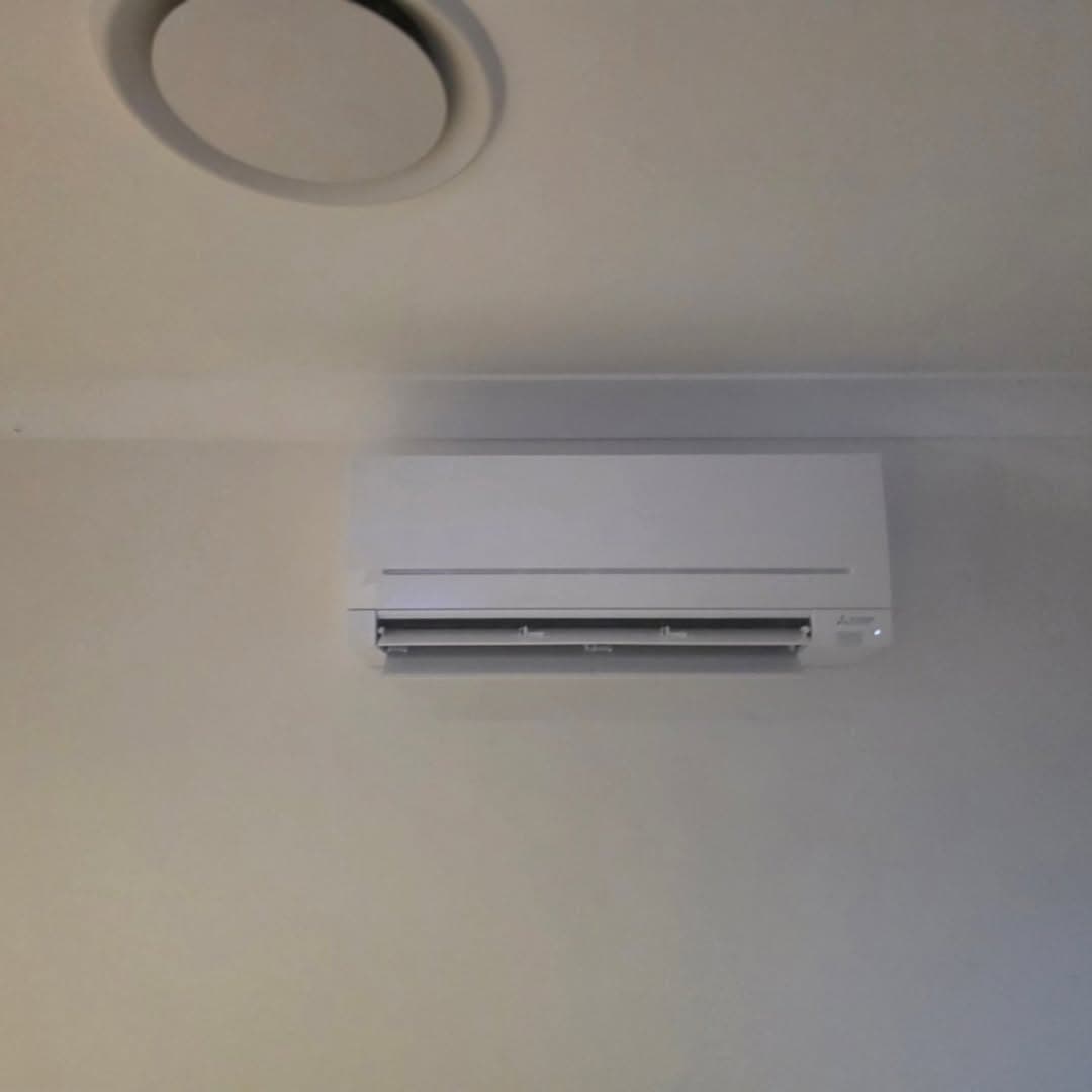 Air conditioning outdoor unit installed on brick wall — Brisbane