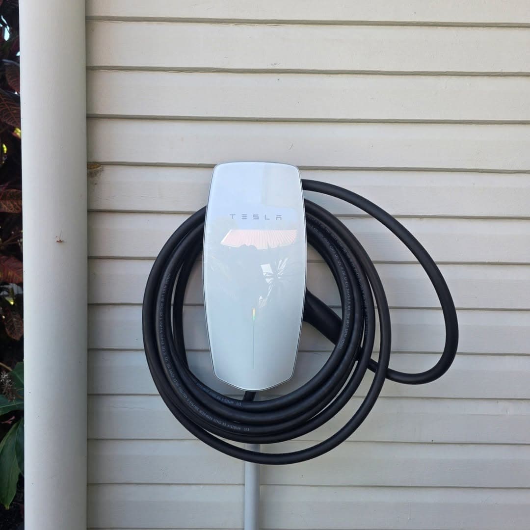 Tesla Wall Connector installed outdoors on weatherboard home